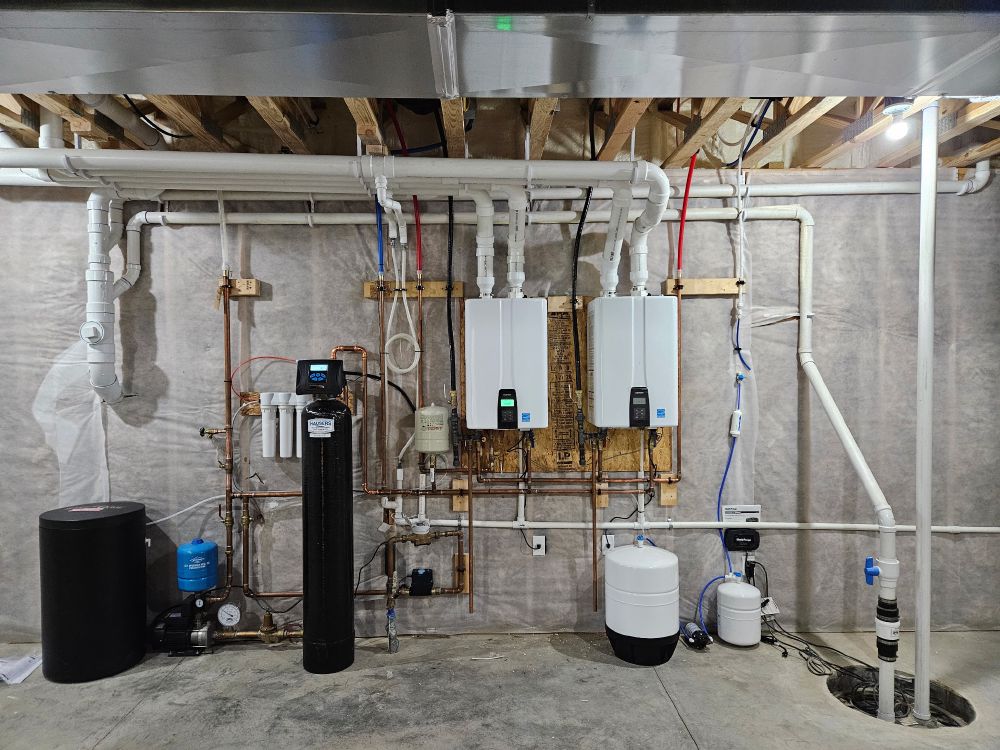 Mechanical room with two Navien tankless water heaters, water softener, and reverse osmosis system